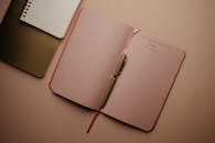 Pink Notebook With Pen on the Table