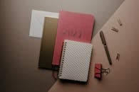 Stack of Notebooks Near the Pink Binder Clip