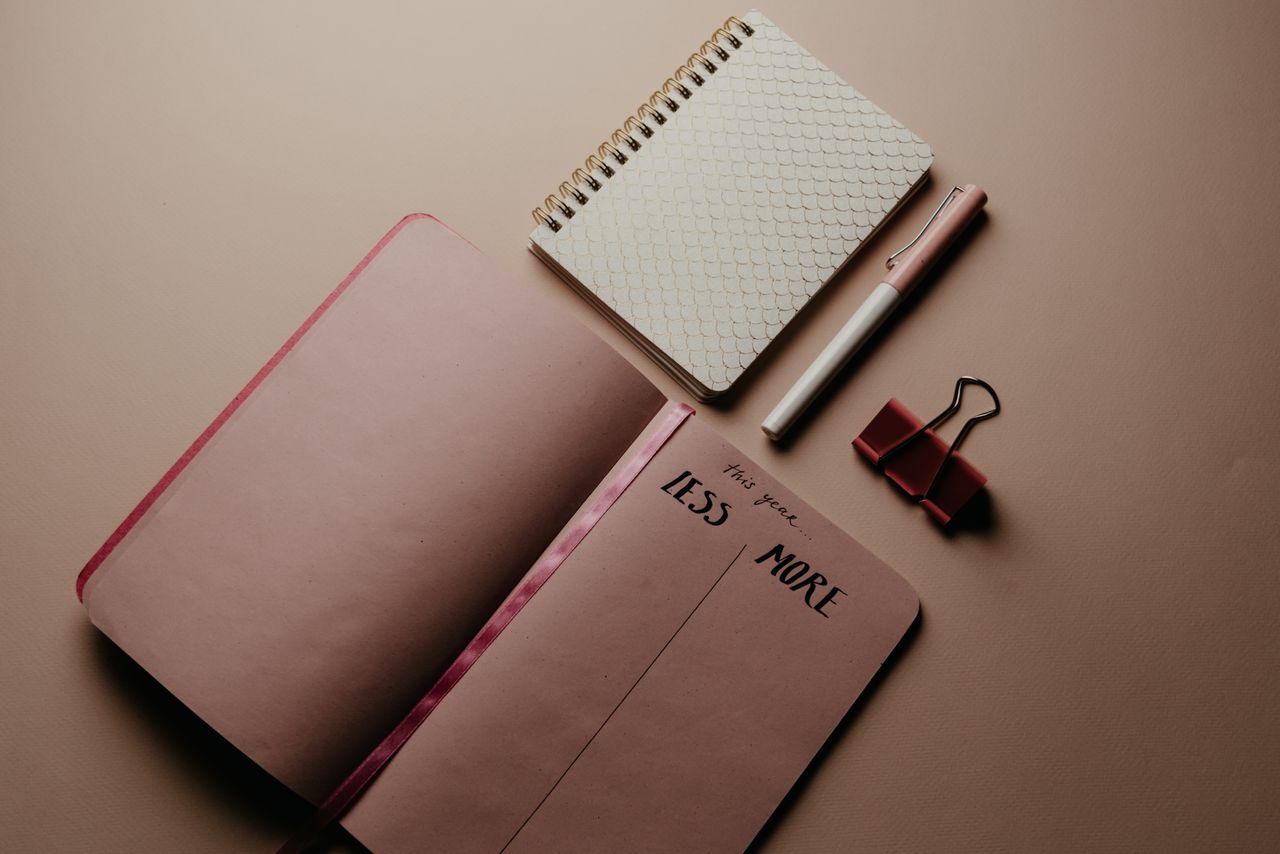top view of minimalist stationery items including notebooks and a pen