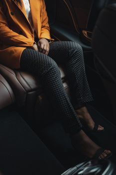 一位穿着时尚的女士坐在豪华车内，散发着优雅与力量