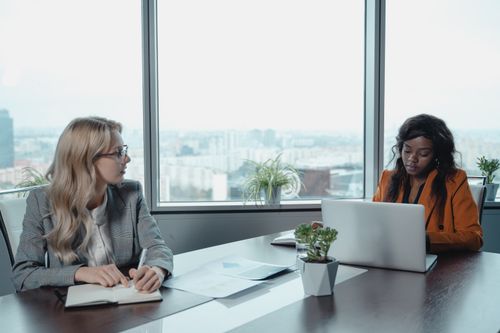 Free Two diverse female professionals collaborating in a bright office environment. Stock Photo