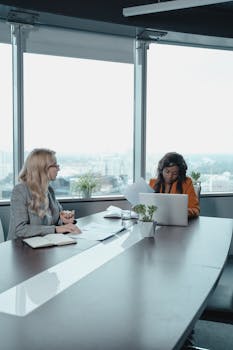 Professional women engaged in a meeting in a contemporary office setting.