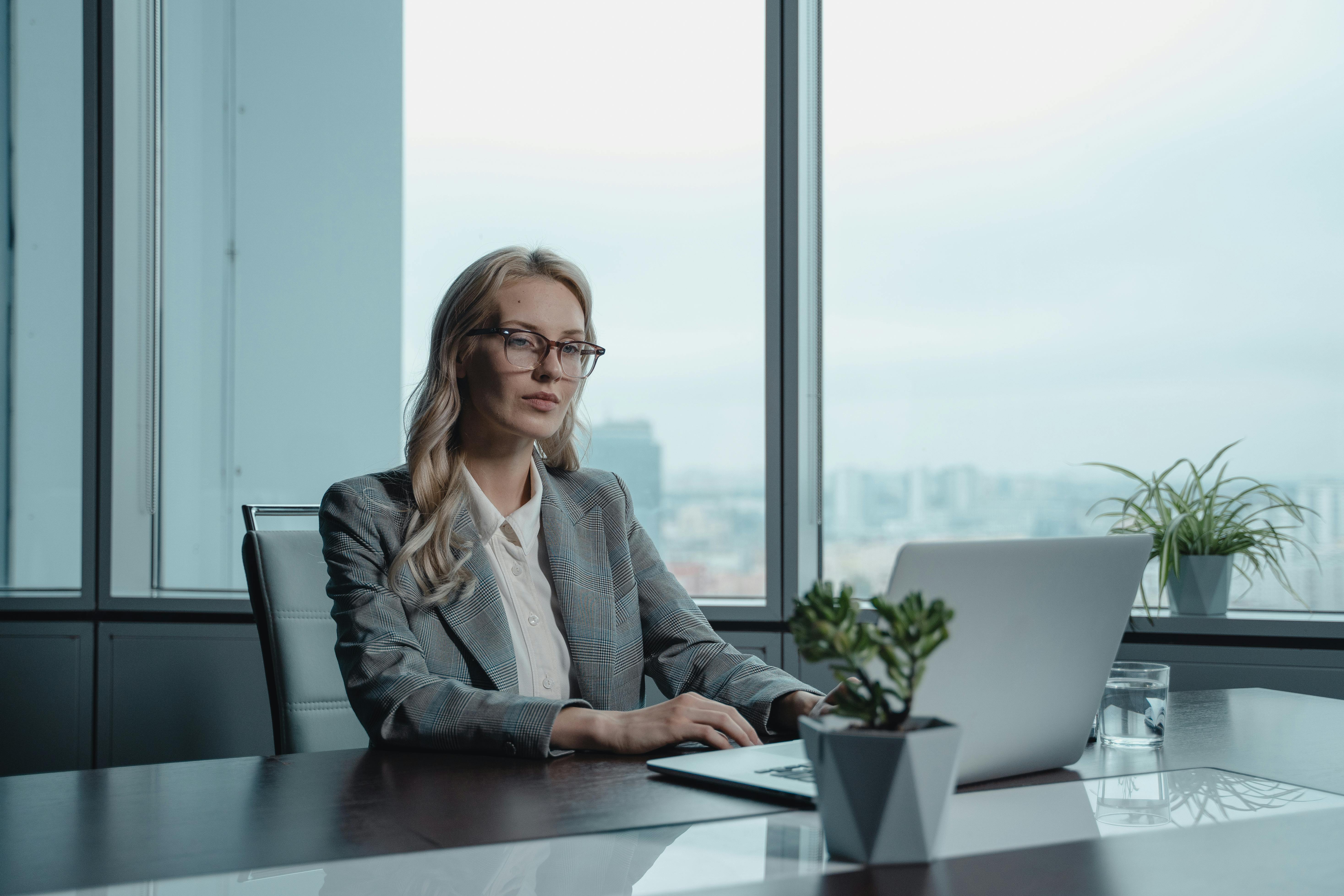 woman in gray blazer sitting by the table