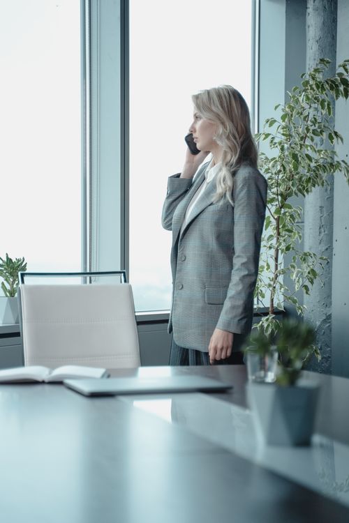 Free A professional businesswoman talking on the phone in a modern office setting with natural light. Stock Photo