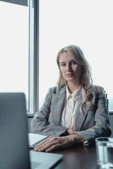 现代办公环境中，一位自信的女商人坐在办公桌旁