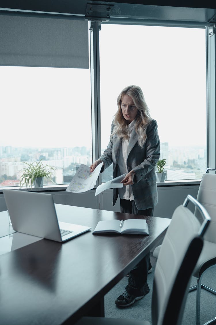 Woman In Gray Blazer Standing Beside Table