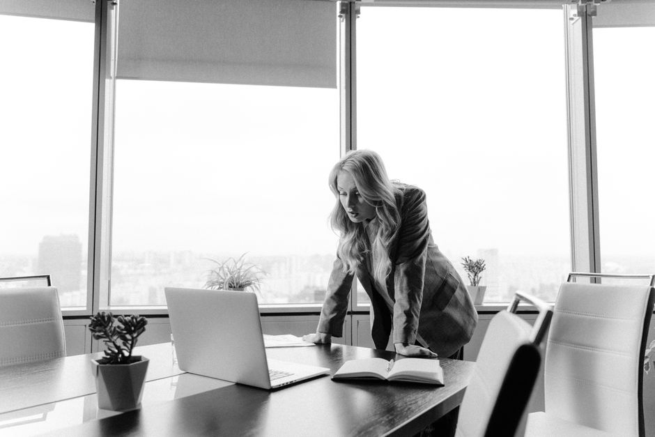 Businesswoman strategizing in a bright office with city views.