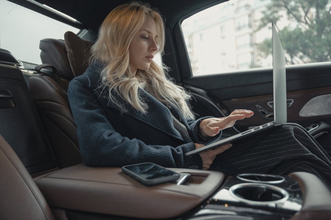 Woman Using Laptop While In The Car