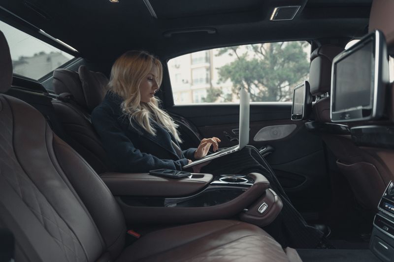 Founder working from the back seat of a car, capturing a LinkedIn post idea on the go