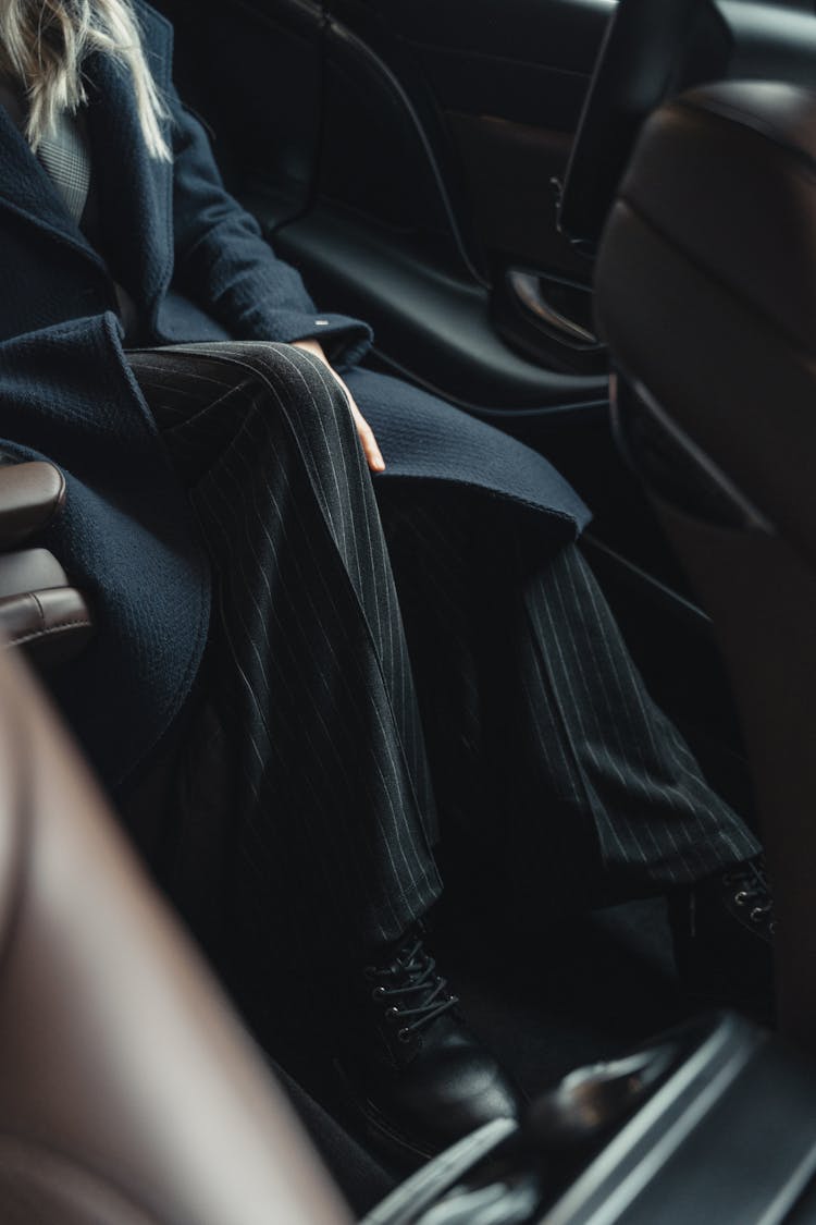 Woman In A Business Attire Seated On A Car 