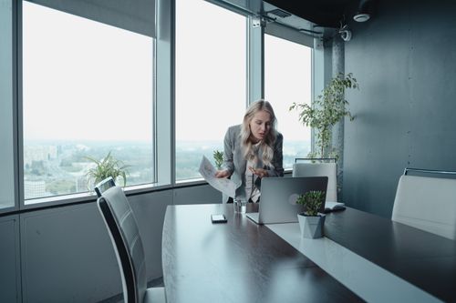 Free Professional woman engaged in a video call in a high-rise office with a scenic view. Stock Photo