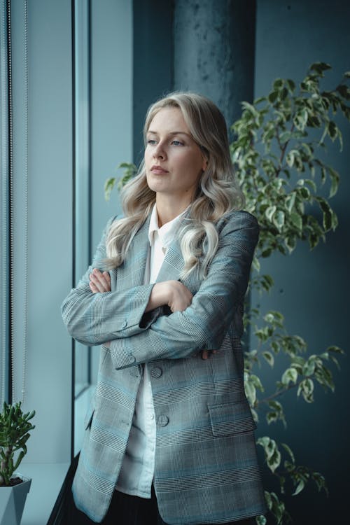 Free Woman in Gray Blazer Standing Near Green Plant With A Serious Look Stock Photo