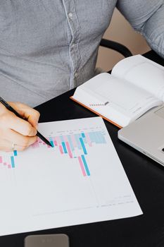 特写：一个人正用笔记本电脑分析图表，进行业务规划