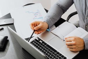 Reviewing a roadmap printout beside a laptop — photo by Kaboompics on Pexels
