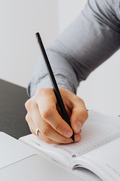 Free A Person Holding a Pen Stock Photo