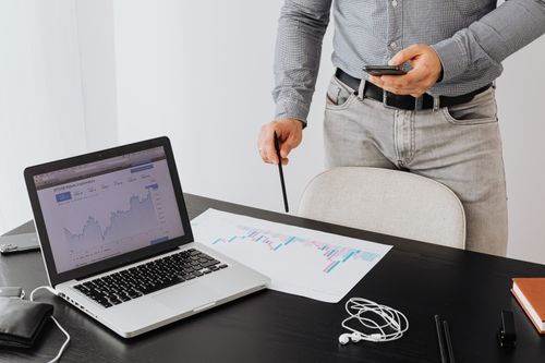Free Business professional analyzing cryptocurrency trends on a laptop with graphs and charts. Stock Photo