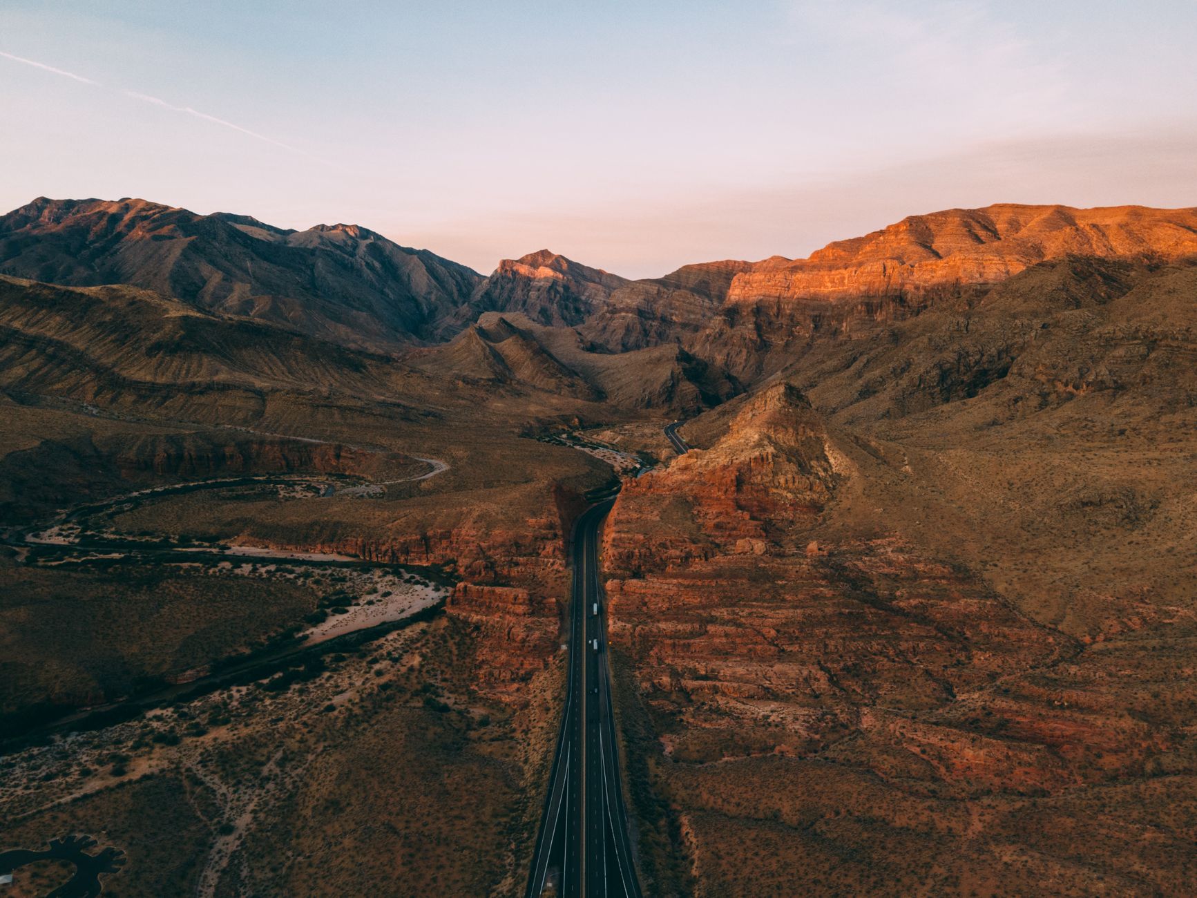 Breathtaking aerial view of Arizona's desert mountains and winding roads at sunset.