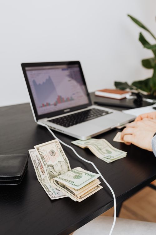 Free Money and laptop on desk indicating financial work or analysis. Perfect for business themes. Stock Photo