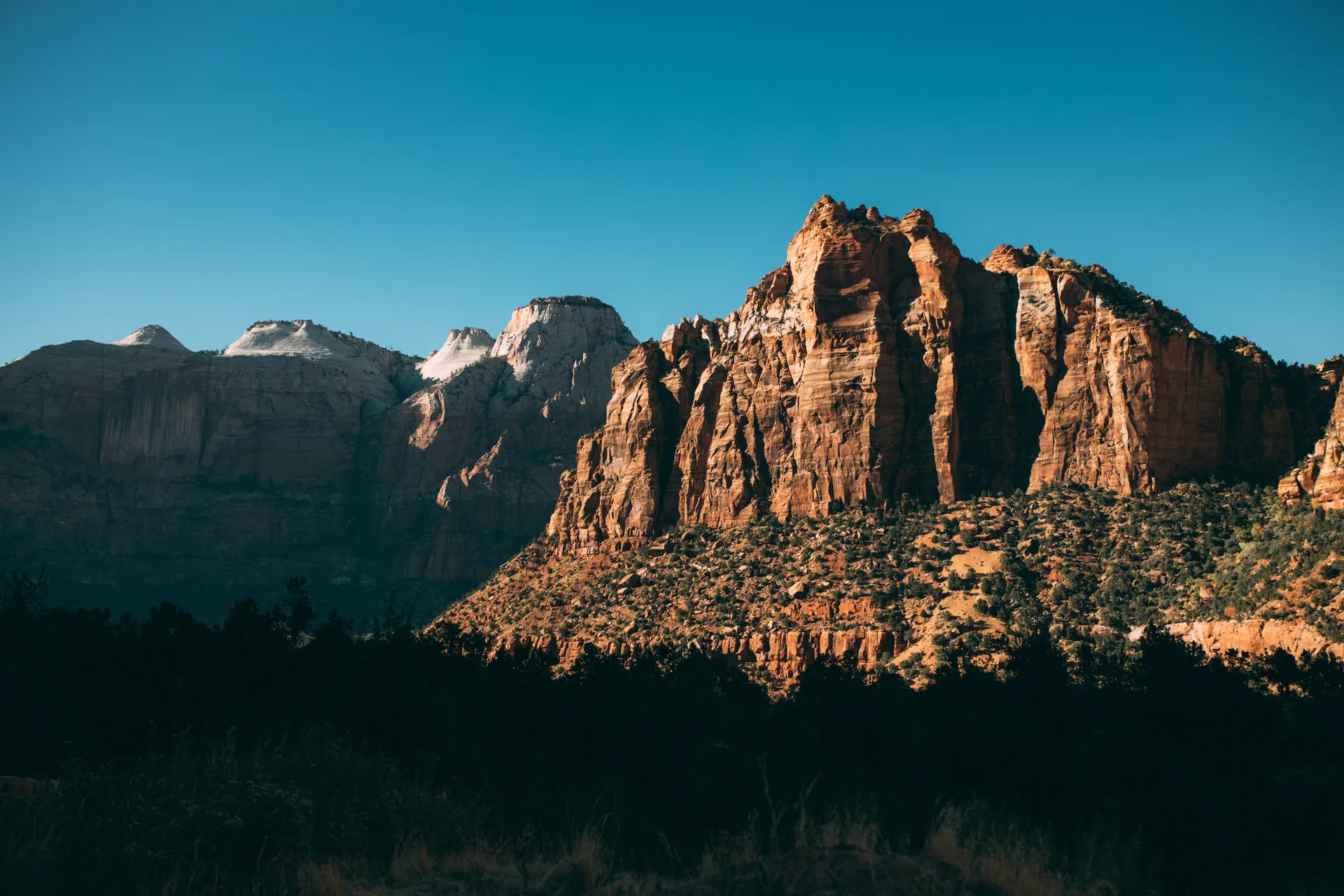 View of cliffs in Zion National Park under clear blue sky. View of cliffs in Zion National Park under clear blue sky.