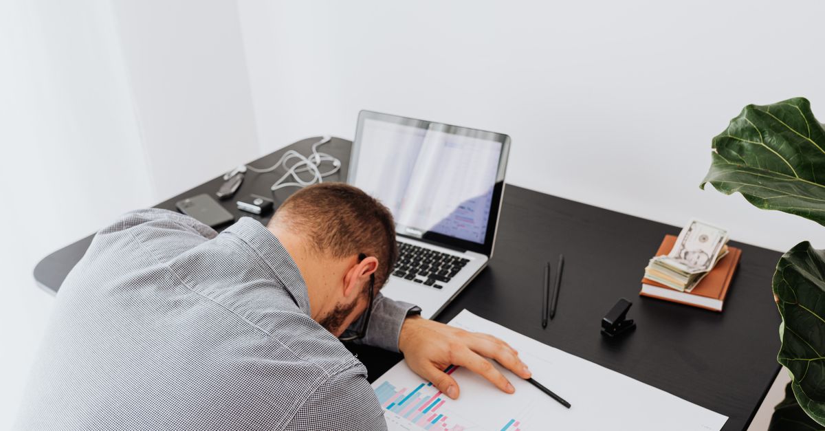 frustrated student looking at laptop with financial charts and debt numbers