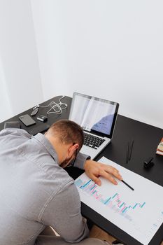 疲惫的人趴在桌上睡着了，周围堆满了工作物品，描绘出压力的氛围