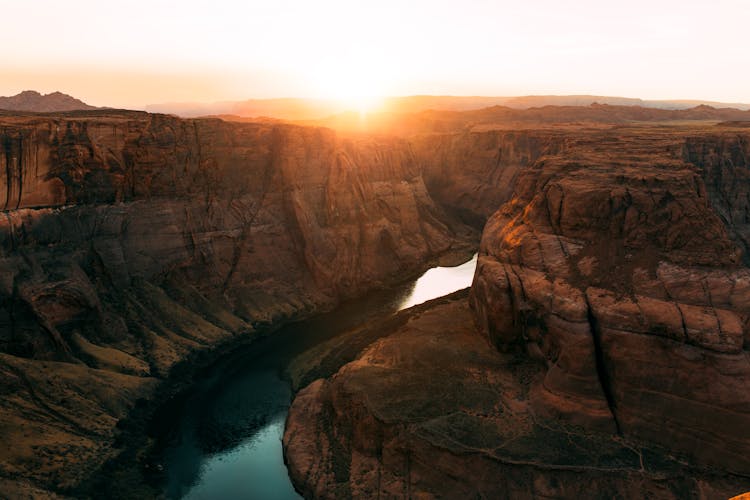 Scenic View Of A River Between Canyons During Sunset