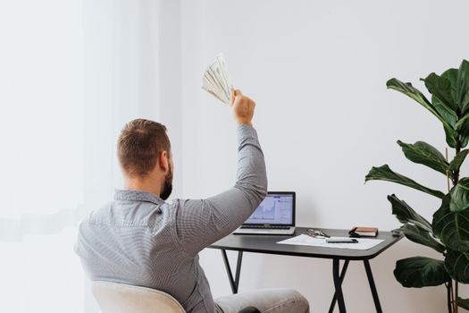 一个人在家办公筹集现金，象征着财务上的成功和成就