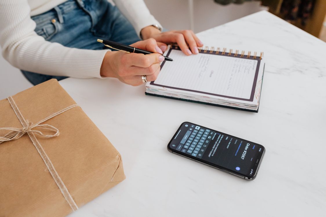 Person Writing on White Notebook · Free Stock Photo