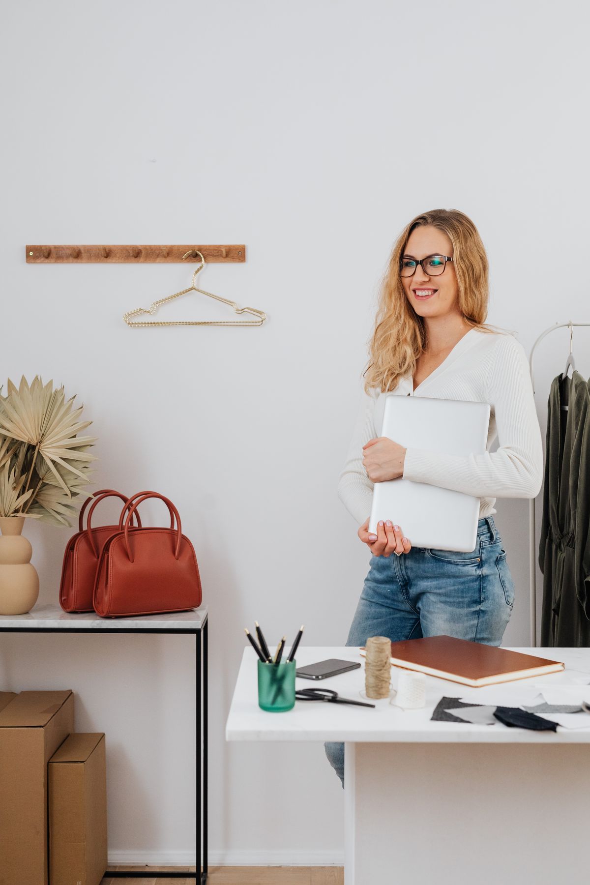 Professional person holding a laptop in a modern office