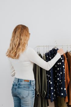 一位金发女子正在精品店里挑选衣服