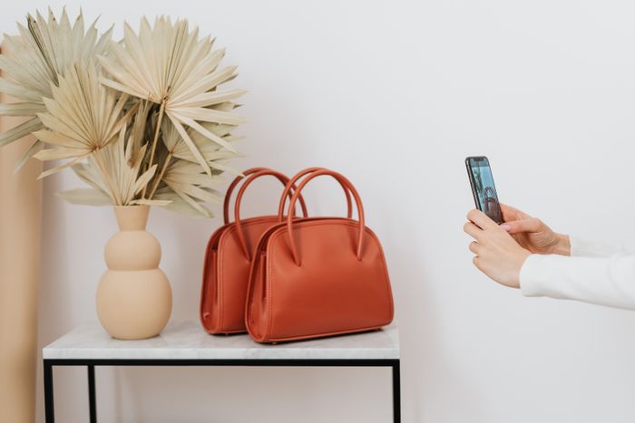 Zwei Handtaschen werden mit dem Smartphone für eine Anzeige fotografiert