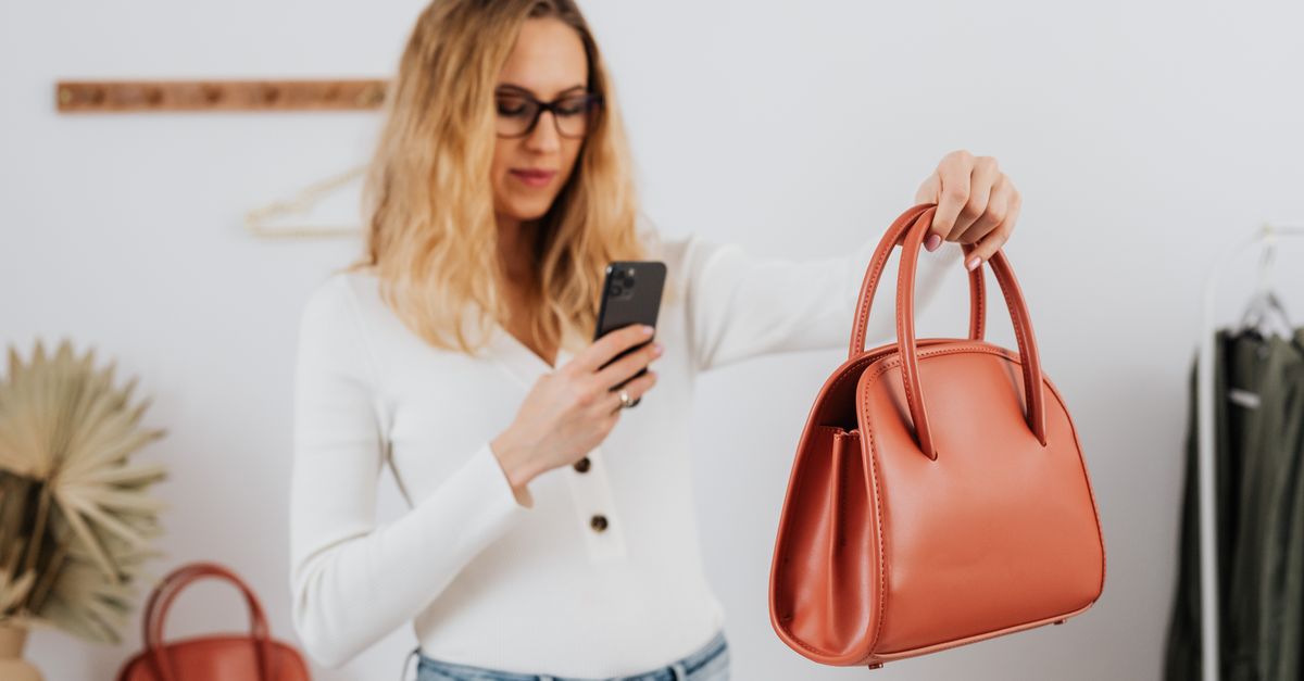 young woman checking phone budget app while shopping in a store