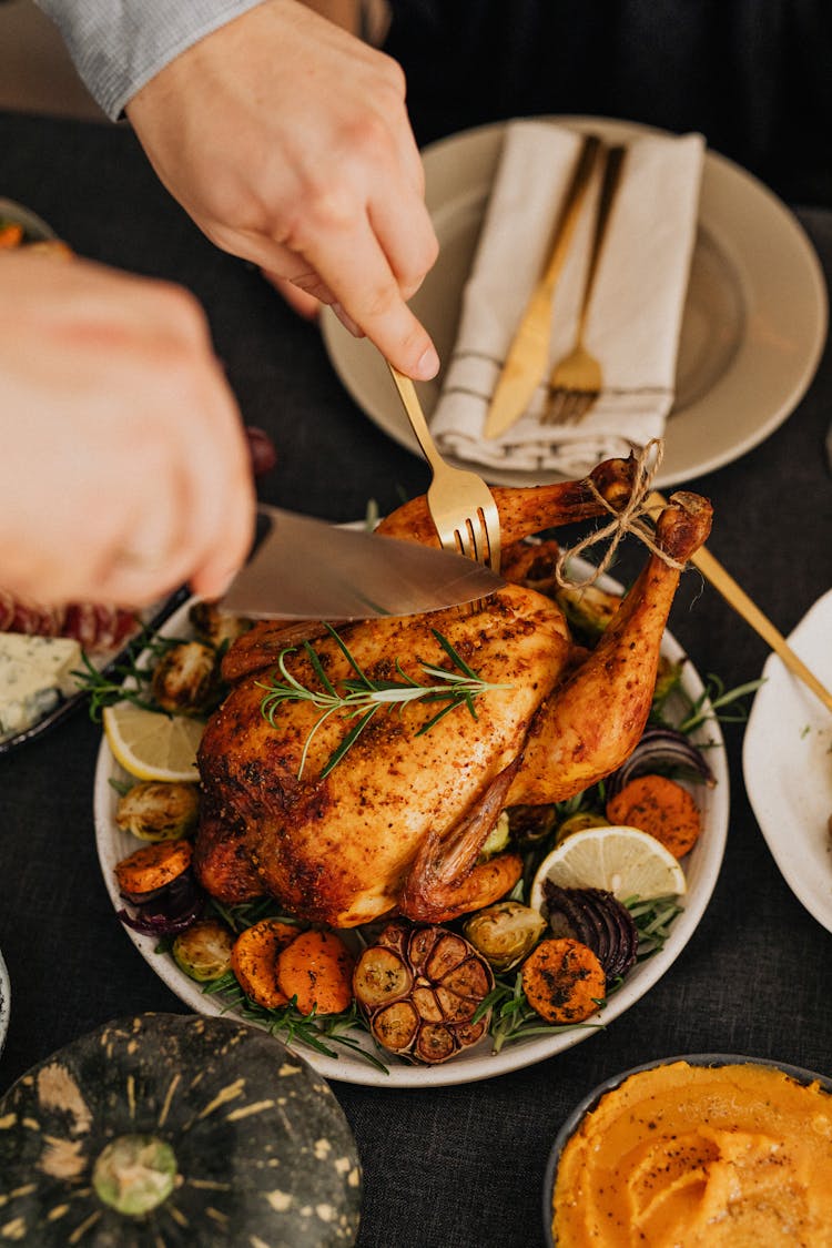 Person Cutting Turkey On Thanksgiving Table