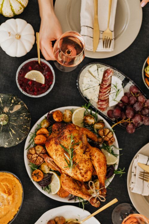 Free Top-down view of a Thanksgiving feast featuring roasted chicken, sides, and wine. Stock Photo
