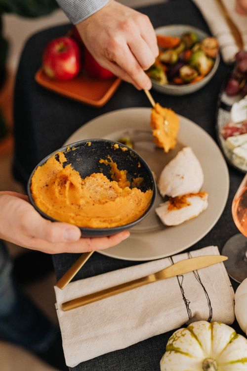 Free A cozy autumn meal featuring mashed squash, roasted chicken, and seasonal sides. Stock Photo