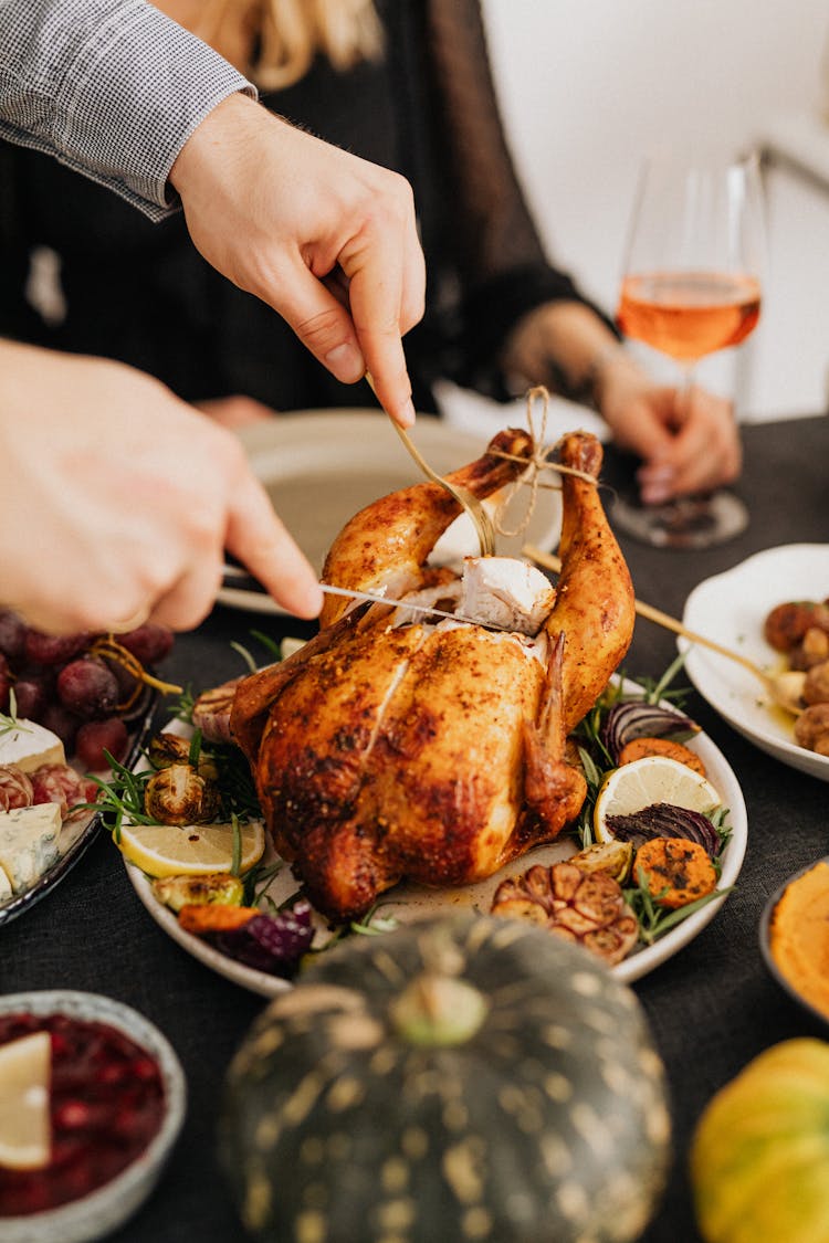 A Person Slicing Roasted Chicken