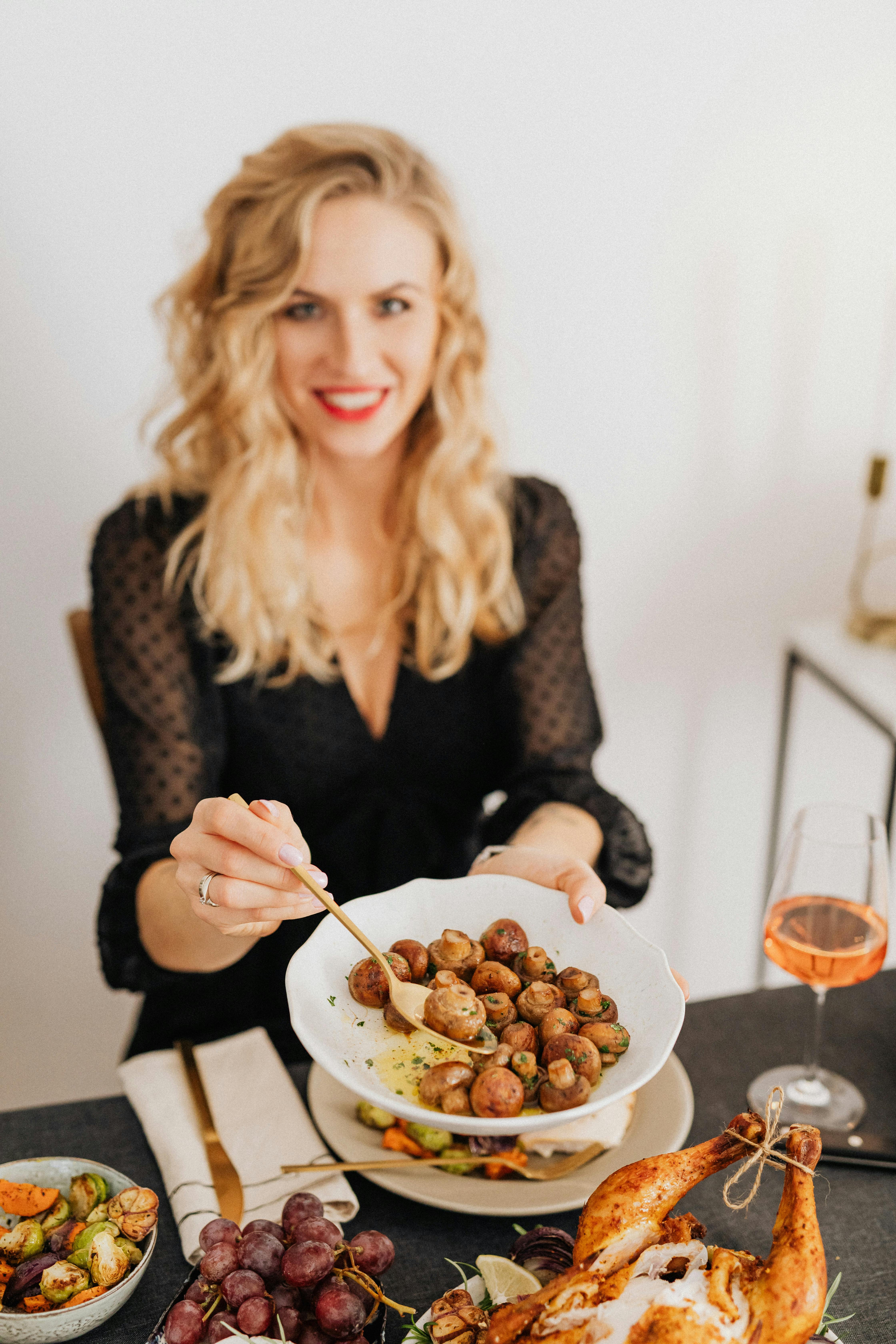 smiling woman holding a plate with meatballs