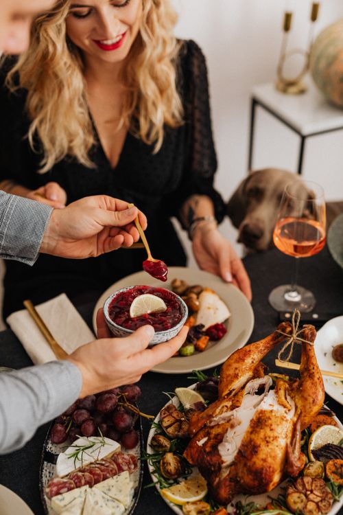 Free A couple enjoying a festive dinner with roasted turkey and sides, perfect for celebrations. Stock Photo
