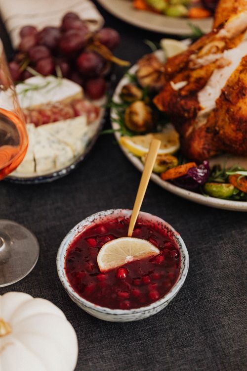 Free A close-up of a Thanksgiving meal featuring cranberry sauce, roasted turkey, and wine. Stock Photo