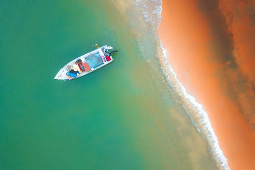 Boat sailing near sandy coast of ocean