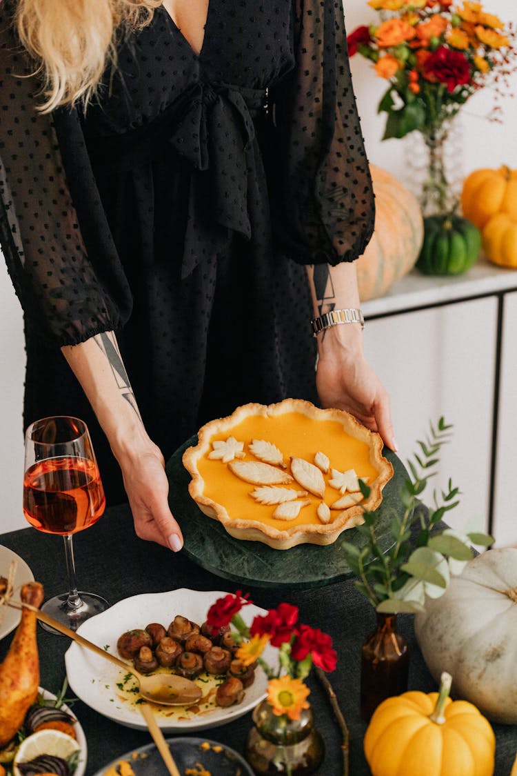 Woman Serving Pumpkin Pie At Thanksgiving