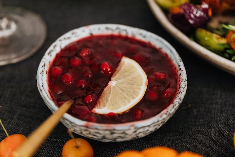 Bowl Of Cranberry Dessert With Lemon Slice And Chopstick