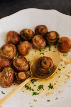 Tantalizing close-up of savory roasted mushrooms with herbs on a plate.
