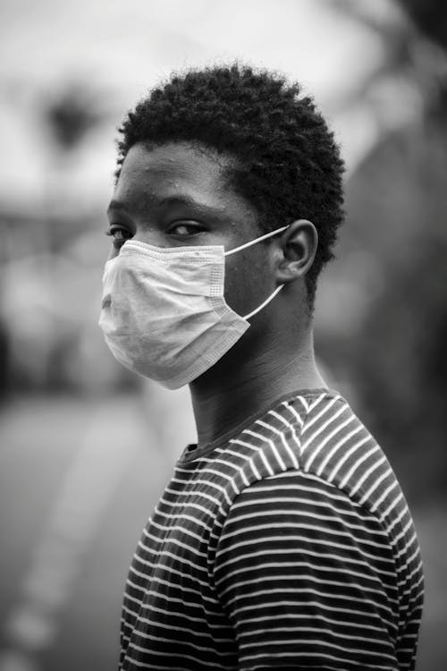 Grayscale Photo of Man in Stripe Shirt With Face Mask