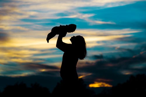 Free Silhouette of Woman Holding a Baby Stock Photo