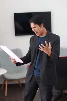 穿着黑色西装的商务人士在办公室拿着文件时会情绪激动