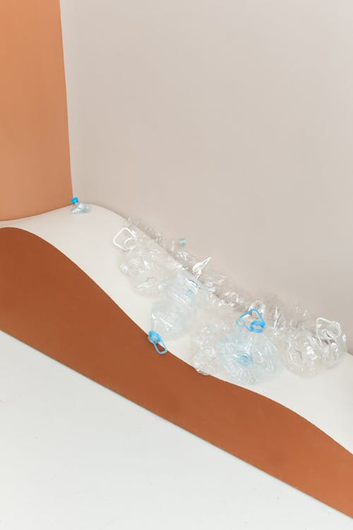 Empty Clear Plastic Bottles on Brown and White Surface