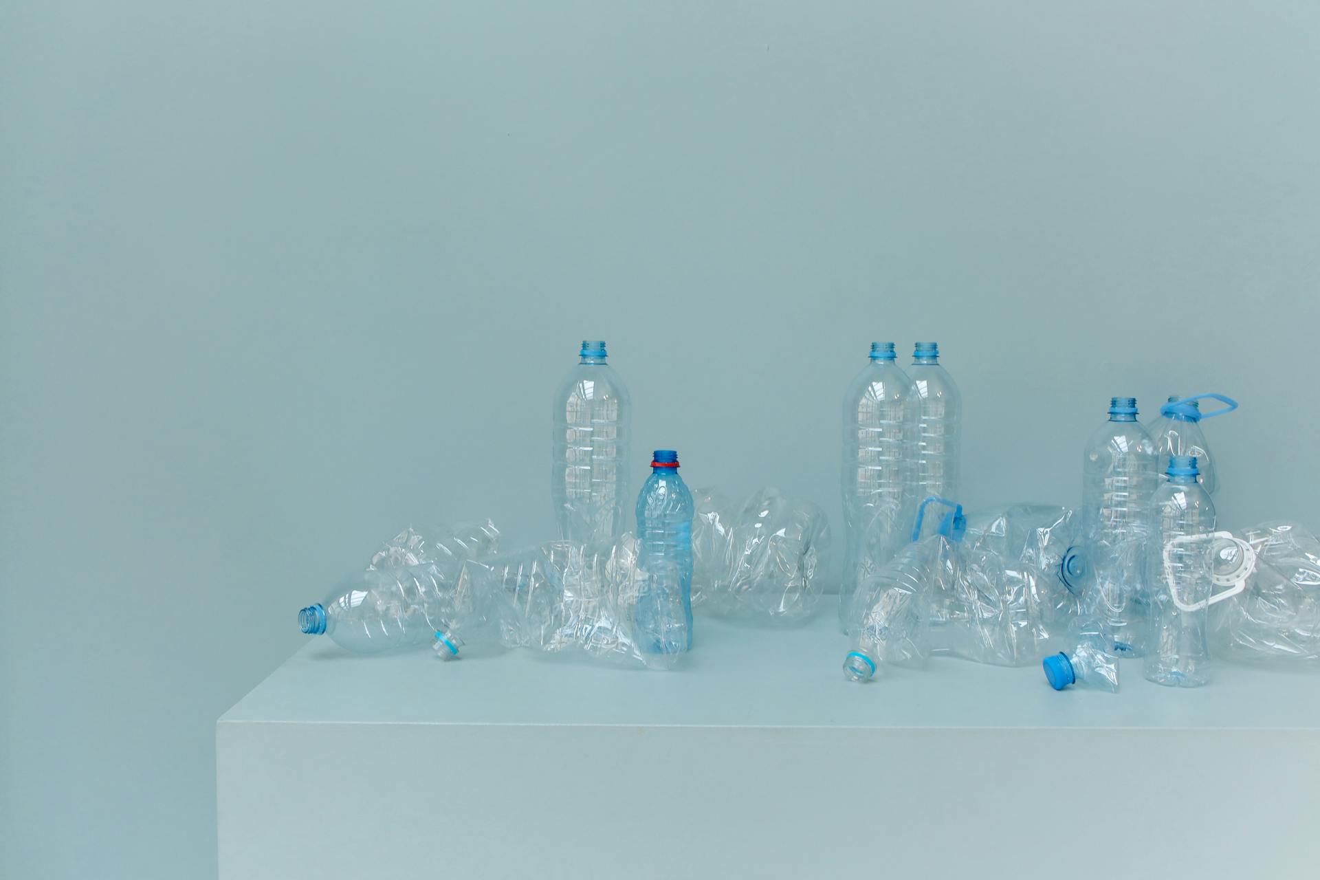A collection of empty plastic bottles arranged on a white surface, highlighting recycled materials.