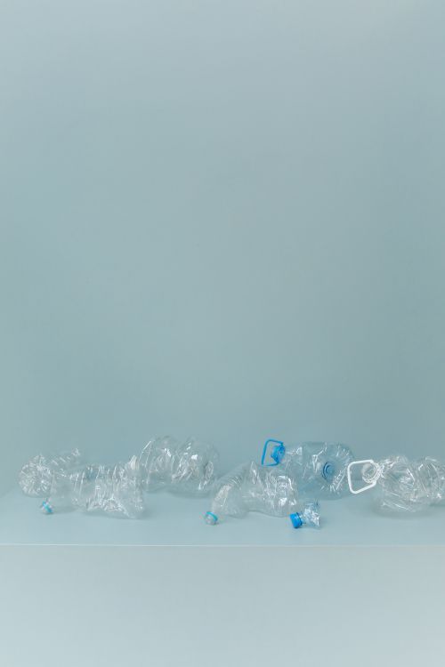 Free A collection of crumpled plastic bottles arranged on a minimalist white surface, highlighting environmental concerns. Stock Photo