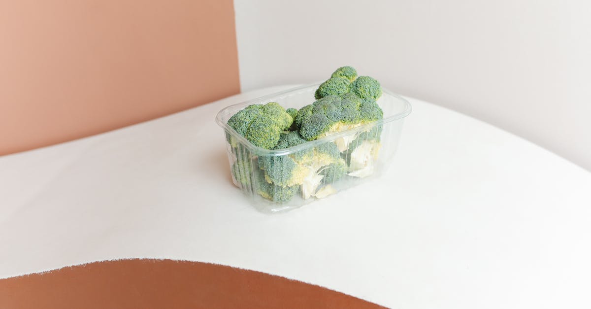Minimalist photo of fresh broccoli in a plastic container on a modern backdrop. Minimalist photo of fresh broccoli in a plastic container on a modern backdrop.